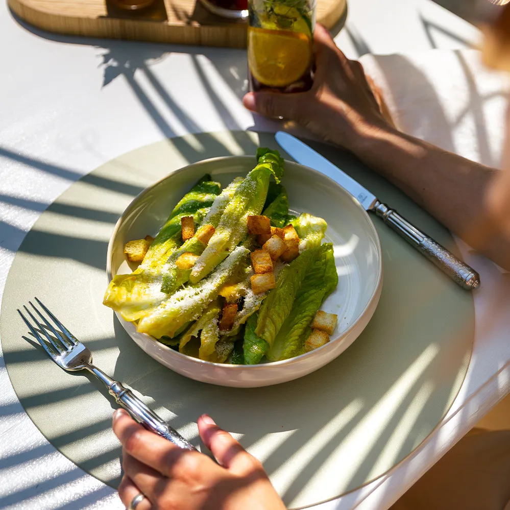 Salade César avec feuilles de salade, croûtons et parmesan, servie dans une assiette